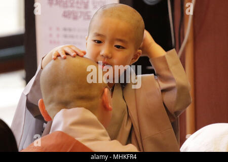 Seoul, South Korea. 2nd May, 2018. A child gets his head shaved by a Buddhist monk during the 'Children Becoming Buddhist Monks' ceremony forthcoming buddha's birthday at a Chogye temple in Seoul. The children will stay at the temple to learn about Buddhism for 20 days. Credit: Ryu Seung-Il/ZUMA Wire/Alamy Live News Stock Photo