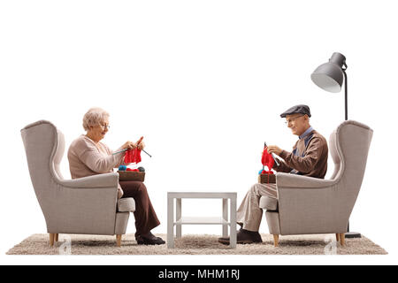 Seniors sitting in armchairs and knitting isolated on white background Stock Photo