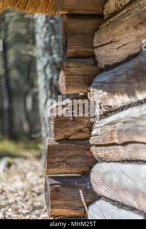 Corner of Estonia old wooden house made of logs and window in a wooden frame Stock Photo