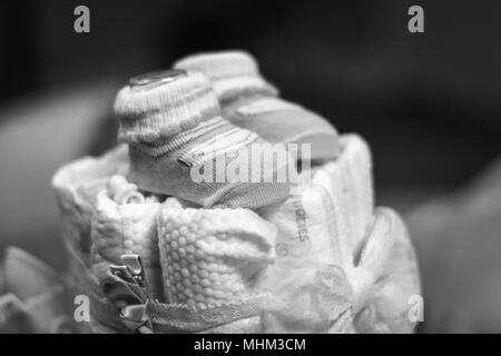 Little socks sit on top of a cake made from diapers in celebration of a baby on the way. Stock Photo