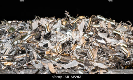 Tangle of glossy metal shavings. Close-up of the pile of manufacturing metallic chips on black background. Industry, mechanical engineering, machining. Stock Photo