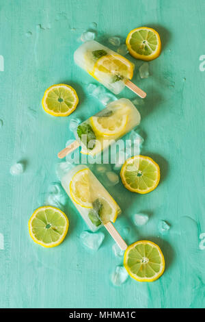 Lemon and mint detox ice cream popsicles on turquoise background Stock Photo