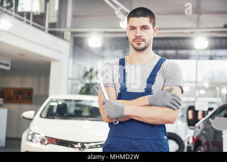 Hand of car mechanic with wrench. Auto repair garage Stock Photo