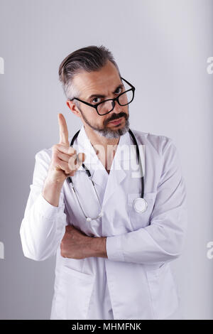 Portrait of middle age doctor wearing eyeglasses with pointing finger Stock Photo