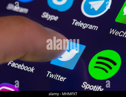 Finder pressing Twitter icon on a smartphone or tablet to run the Twitter app. Stock Photo