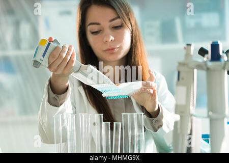 student woman with multi pipette and other PCR items in microbiological / genetic laboratory Stock Photo