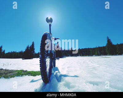 Cycling on large tyres in fresh snow. Biker goes by bike on the snowy road in the mountains. Picture taken in HDR mode. Stock Photo