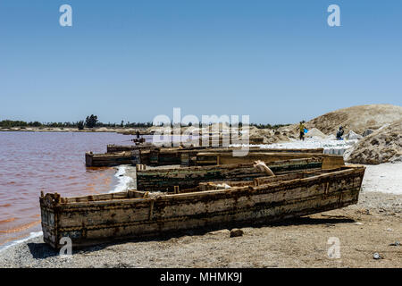 African boats on the coast of the pink water lake in Senegal, Africa Stock Photo
