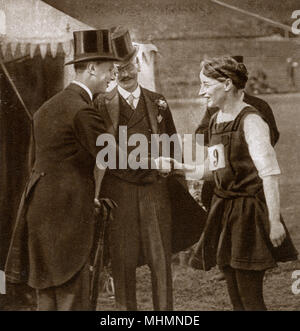 Prince Albert (future King George VI) (1895-1952), who had just become Duke of York visiting the Civil Service Sports Day at Stamford Bridge (the home of Chelsea Football Club). The picture shows him shaking hands with Miss D. Leach, a competitor.     Date: 1920 Stock Photo