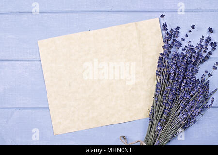 Overhead view of a bundle of dried lavender flowers with an old piece of paper with copy space. Stock Photo