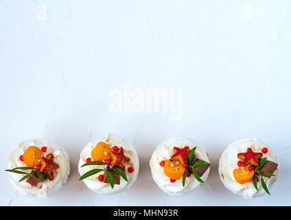 Cake with cream, chocolate cakes with biscuits, four paper cups. Close-up on white background. Horizontal view. Free space for text. Healthy food. Stock Photo