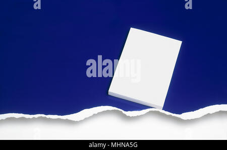 Graphic resource. Blank cover book against a ripped blue background. Clipping path on cover book. Stock Photo