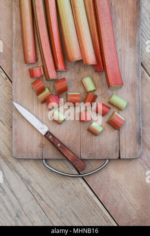 Rheum rhabarbarum. Chopped Rhubarb on a wooden board Stock Photo