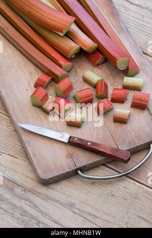 Rheum rhabarbarum. Chopped Rhubarb on a wooden board Stock Photo