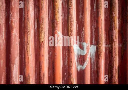 Weathered corrugated red rusty metal sheet, abstract background. Stock Photo