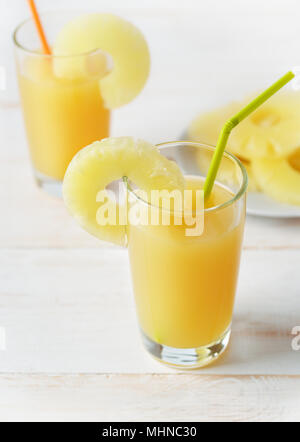 Two glasses of pineapple juice on white wooden table Stock Photo
