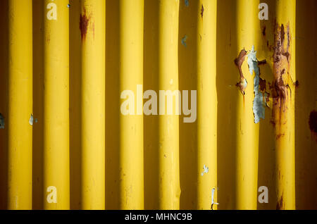 Weathered corrugated yellow rusty metal wall, abstract background. Stock Photo