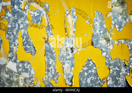 Weathered metal wall with peeling yellow paint, abstract background. Stock Photo