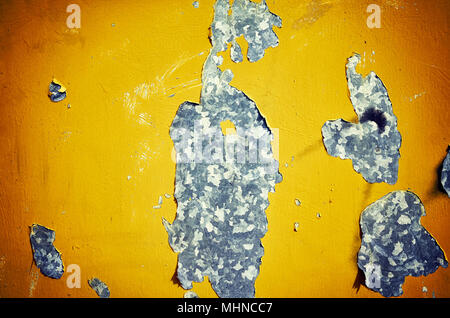 Weathered metal wall with peeling yellow paint, abstract background. Stock Photo