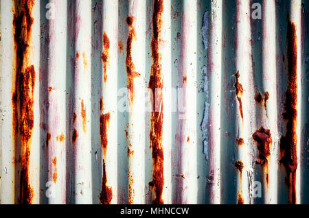 Weathered corrugated rusty metal painted wall, abstract background. Stock Photo