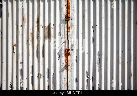 Garage corrugated metal door with peeling paint. Stock Photo