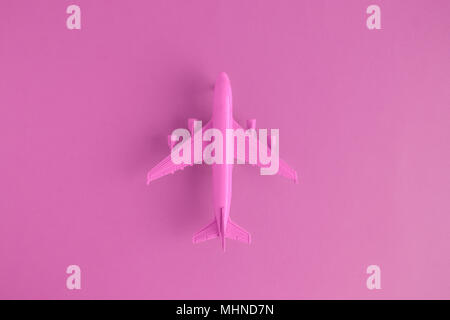 Flat lay of miniature toy airplane on pink background minimal trip and travel creative concepts. Stock Photo