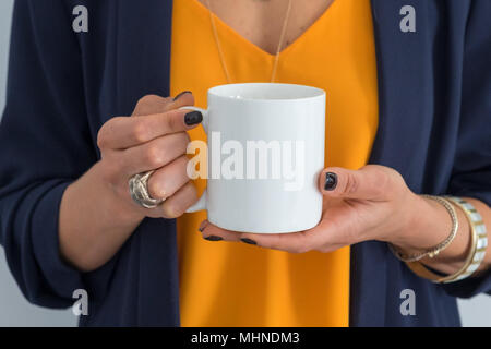 womans hands holding a blank white coffee mug, perfect for displaying your quote, design on mugs you sell. Stock Photo