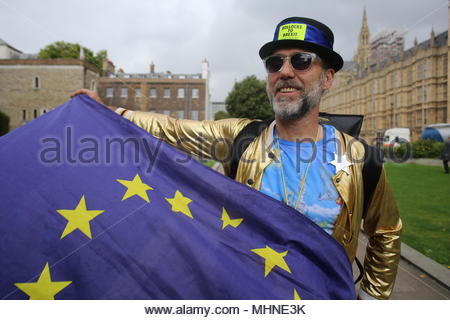An anti-Brexit protestor waves the EU flag to photographers at Westminster with Big ben and the Palace of Westminster in the background. Stock Photo