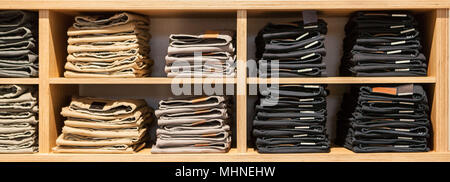 Jeans pants on the store shelf. Blue jeans denim Collection jeans stacked Stock Photo