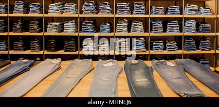 Jeans pants on the store shelf. Blue jeans denim Collection jeans stacked Stock Photo