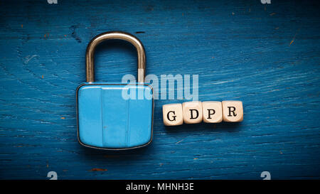 Old used padlock on a blue rustic wooden background, GDPR concept image Stock Photo