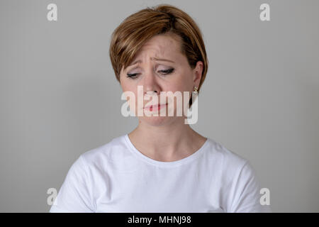 Close up portrait of a beautiful young red haired caucasian woman with a sad face. looking miserable and melancholy. Human facial expressions and emot Stock Photo
