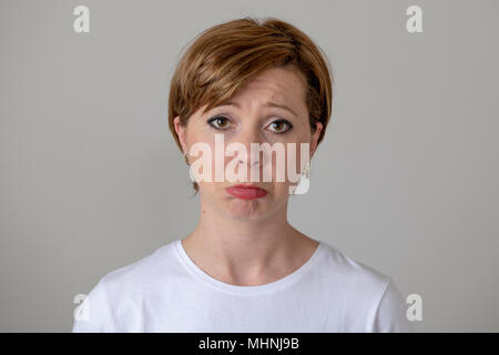Close up portrait of a beautiful young red haired caucasian woman with a sad face. Attractive female looking miserable at the camera.Human facial expr Stock Photo