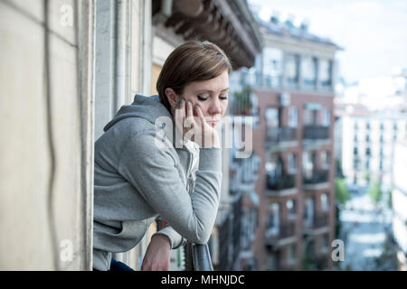 Young attractive, unhappy sad caucasian woman suffering from depression looking thoughtful on the balcony at home. In depressed and anxiety female con Stock Photo