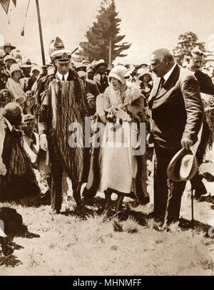 Duke and Duchess of York visiting the Rotorua District - pictured with Sir Apirana Ngata, parliamentary representative of the Eastern Maori people. They are both wearing robes presented to them during the gathering.     Date: 1927