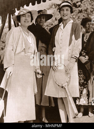 Elizabeth, Duchess of York (later Elizabeth, the Queen Mother 1900-2002) and Helen Wills Moody (1905-1998) at the Lawn Tennis Championships at Wimbledon. Princess Marie Louise of Schleswig-Holstein (1872-1956) stands behind the     Date: 1935 Stock Photo