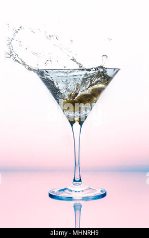 A splash of martini in a cocktail glass with olives. Stock Photo