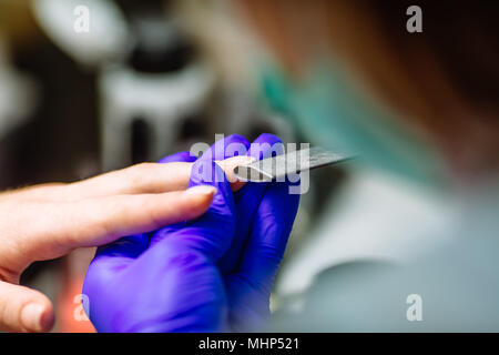 Manicure care procedure, Woman in a nail salon receiving a manicure by a beautician. Closeup shot. Stock Photo