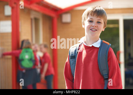 Portrait Of Boy Wearing Uniform Standing In School Playground Stock Photo