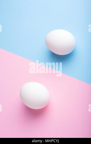 Two eggs on flat lay blue pink paper background Stock Photo
