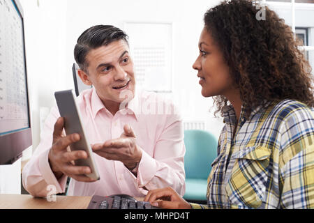 Man Training Woman In Office Using Digital Tablet Stock Photo
