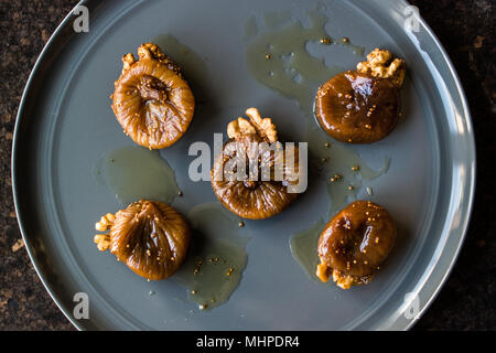 Dried Fig Dessert with Walnut / Cevizli incir tatlisi in a grey plate. Stock Photo