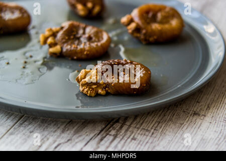 Dried Fig Dessert with Walnut / Cevizli incir tatlisi in a grey plate. Stock Photo