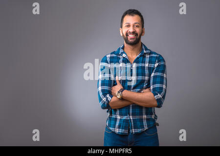 A young black man standing confidently with his arms folded Stock Photo