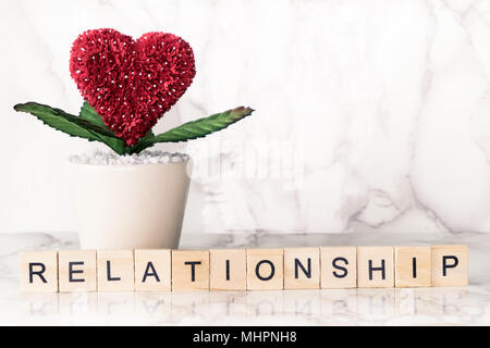 Relationship text on wood with heart shaped flower on marble copy space Stock Photo
