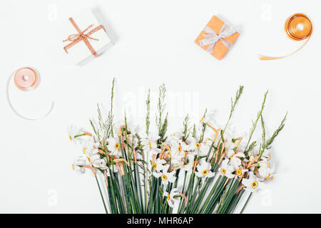 Beautiful white flowers, small gift boxes and ribbons on the table, top view Stock Photo