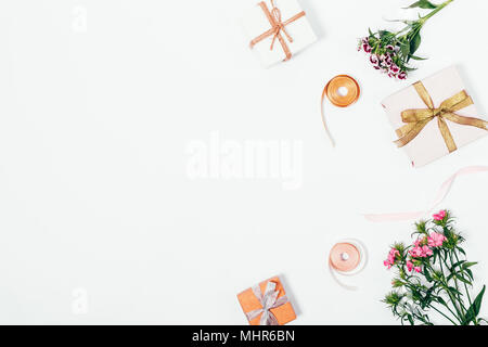Pink flowers, gift boxes with ribbons on a white table top view, space for text Stock Photo