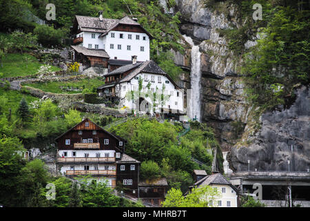 Houses in the mountain next to waterfall Stock Photo