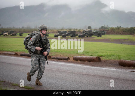 Staff Sgt. Gary G. Olsen-Saville of the 1984th United States Army Hospital Detachment 2 runs towards the finish line of the 12-mile ruck march during the Best Warrior Competition at Schofield Barracks, Hawaii Mar. 2, 2018.  The Best Warrior Competition recognizes Soldiers who demonstrate commitment to the Army Values, embody the Warrior Ethos, and represent the Force of the Future. Stock Photo