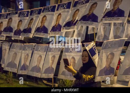 Kuala Lumpur, Malaysia. 3rd May, 2018. A women seen taking selfie with a Barisan Nasional political poster at a Pakatan Harapan politic campaign at PPR Kerinchi, Kuala Lumpur.Malaysia will hold 14th General Election on 9th May 2018 and it's less than 1 week for political parties to hold their political campaign and manifesto. Pakatan Harapan the opposition party seen blaze with hundreds of people attend their political campaign. Credit: Faris Hadziq/SOPA Images/ZUMA Wire/Alamy Live News Stock Photo